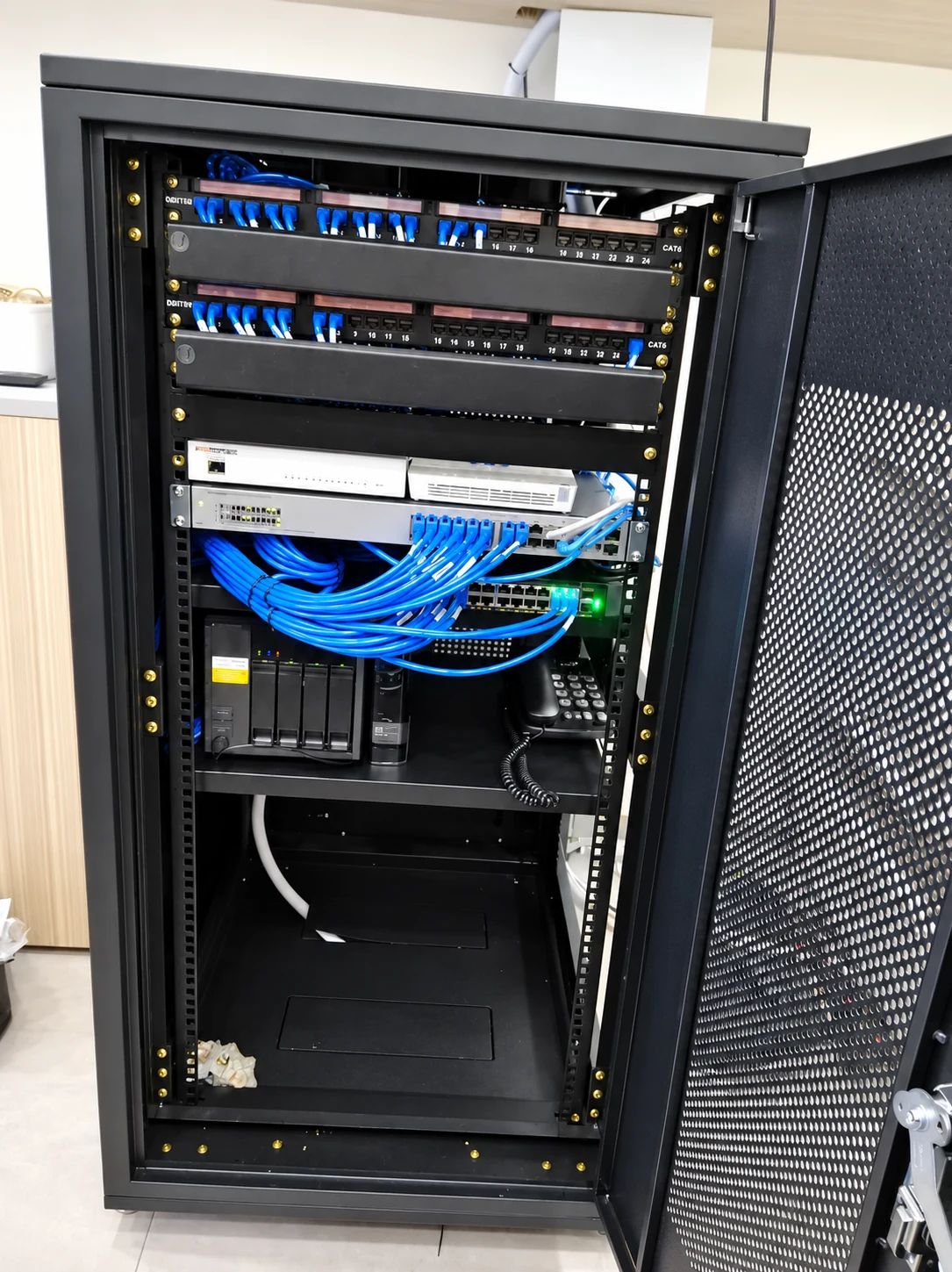 Completed office network rack with organised blue cabling and installed equipment